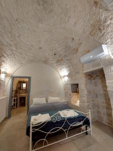una camera con un letto in una parete in pietra di Trulli Carlo Anna a Locorotondo