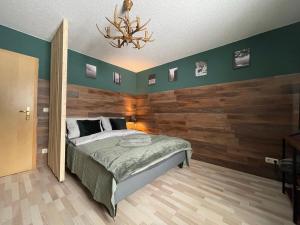 sypialnia z łóżkiem i drewnianą ścianą w obiekcie Ferienwohnung Augenblick w mieście Altenberg