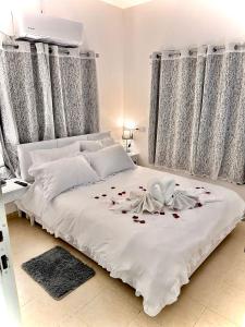 Un dormitorio con una cama blanca con rosas. en Dream, en Midrakh ‘Oz