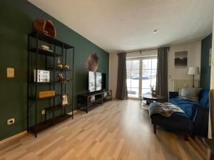 ein Wohnzimmer mit grünen Wänden und einem blauen Sofa in der Unterkunft Ferienwohnung Augenblick in Kurort Altenberg