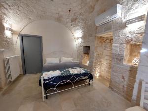 ロコロトンドにあるTrulli Carlo Annaの石壁のベッドルーム1室