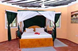 a bedroom with a bed with a canopy at Kaure Sand Beach Lodge in Uroa