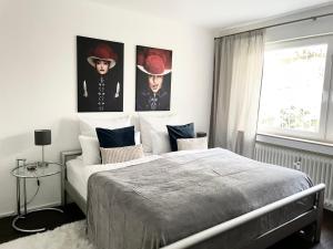 een slaapkamer met een bed met twee foto's aan de muur bij Modernes Apartment mit traumhaftem Sunset Blick in Baden-Baden