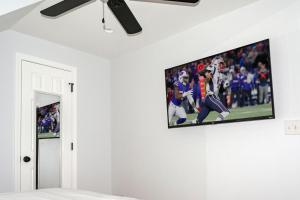 einen TV an der Wand mit einem Fußballspiel darauf in der Unterkunft Queen Bed - Boston - RM 2 in Stoneham