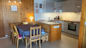 a kitchen with a table and a table and chairs at La petite Silene in Leysin