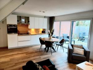 uma cozinha e sala de estar com mesa e cadeiras em Bosweg 9a, Comfortabele vakantiewoning, Centrum Zoutelande em Zoutelande