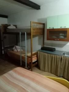 a room with two bunk beds and a kitchen at Affittacamere El Mojito in Calopezzati