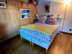 sypialnia z łóżkiem z niebieską kołdrą i poduszkami w obiekcie Appartement 2pieces Hyper Centre Les Houches, proche Chamonix w mieście Les Houches
