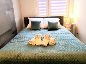 a bedroom with a bed with two pairs of slippers at Apartment DAISY, balcony, 5 os, Down Town in Kraków