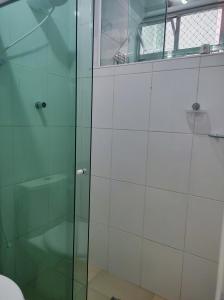 y baño con ducha y puerta de cristal. en Lindo apto vista lateral do mar Itararé São Vicente en São Vicente