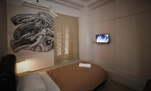 a bedroom with a bed and a tv on a wall at Hotel Ambasador in Bitola