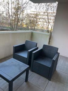 2 sillas y una mesa en el balcón en Lormont- 2 PERSONNES - GRANDE TERRASSE en Lormont