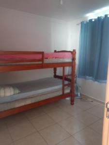 a room with two bunk beds and a blue curtain at Nosso Lar-Ap Rio das Ostras in Rio das Ostras