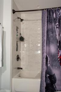 Queen Bed - Boston - RM 3 في Stoneham: حمام مع حوض استحمام وستارة دش