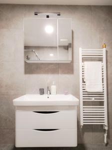 a white bathroom with a sink and a mirror at LanaMarija Apartment in Trebinje