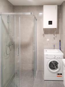 a bathroom with a shower and a washing machine at LanaMarija Apartment in Trebinje
