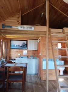 a room with a kitchen and a staircase in a cabin at Noclegi Nowe Warpno in Nowe Warpno