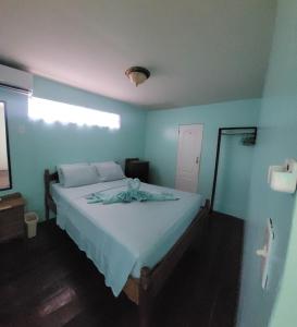 1 dormitorio con 1 cama con pared azul en Axios Sun Apartments Caye Caulker, en Caye Caulker