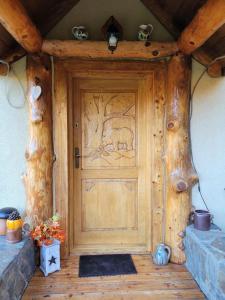 a wooden door with a bear carving on it at Dom w Górach Sowich Niedźwiedzia Gawra, Michałkowa in Michałkowa