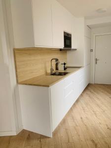 a kitchen with white cabinets and a sink at SAN LORENZO HUESCA con parking in Huesca