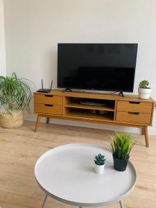 a living room with a tv and a white table at SAN LORENZO HUESCA con parking in Huesca