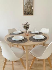 una mesa de madera con sillas blancas alrededor en SAN LORENZO HUESCA con parking, en Huesca