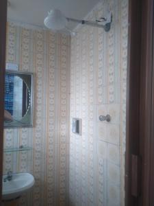 ein Bad mit einem Waschbecken und einem Spiegel in der Unterkunft Apartamento de frente a Praia, pé na areia com wi-fi LOFTJM com 01 vaga de garagem sujeita a disponibilidade in Santos