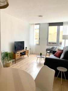 a living room with a couch and a tv at SAN LORENZO HUESCA con parking in Huesca
