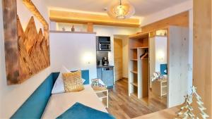 a living room with a couch and a kitchen at Heimat Apartments - Zillertal in Gerlos