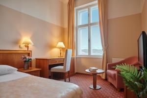 a hotel room with a bed and a desk and a window at Hotel Lovran in Lovran