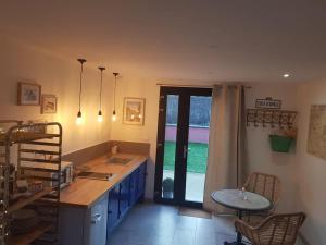 a kitchen with a counter and a table and a window at Le Bon Temps, pour une douce parenthèse in Saint-Martin-lez-Tatinghem