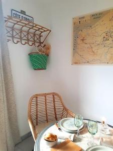 a table with wine glasses and a map on the wall at Le Bon Temps, pour une douce parenthèse in Saint-Martin-lez-Tatinghem