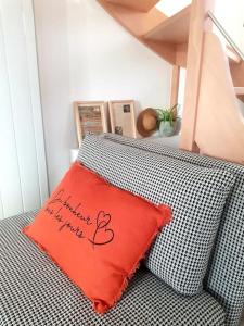 a red pillow sitting on top of a couch at Le Bon Temps, pour une douce parenthèse in Saint-Martin-lez-Tatinghem