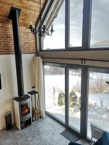 a fireplace in a living room with a view of the snow at WIATR W KOMINIE dostęp do jeziora UBLIK in Konopki Wielkie