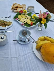 una mesa con platos de comida y fruta. en World's View Wild Camping Salaszoi, Principe Island en Santo António