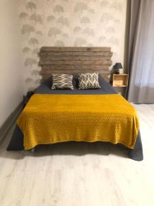 a bedroom with a bed with a yellow blanket on it at Gîte chez BIBI studio 2 à 4 pers in Vacqueyras