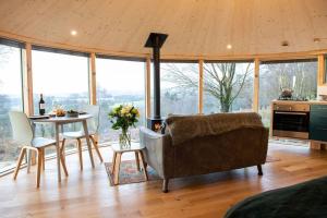 uma sala de estar com um sofá e uma mesa em Luxury romantic Roundhouse and hot tub for two em Glasgow