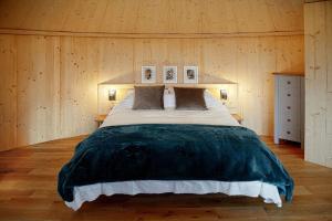 ein Schlafzimmer mit einem großen Bett an einer Holzwand in der Unterkunft Luxury romantic Roundhouse and hot tub for two in Glasgow