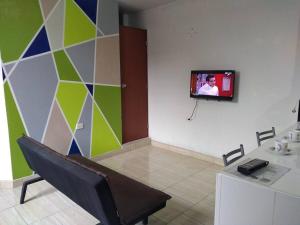 Habitación con TV en la pared y mesa. en Departamento-Parque y Flores M1, en Chiclayo