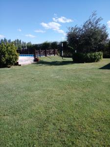 un campo de hierba con una valla en el fondo en Cabañas La Soñada en San Rafael