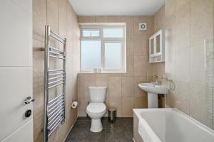 a bathroom with a toilet and a sink and a tub at Two Bedroom Apartment by Dream Key Properties Short Lets & Long Lets Uxbridge- 6 in Uxbridge