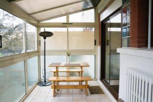 un solárium con una mesa y una lámpara en EXIGEHOME-Grande maison aux portes de Paris, en Antony