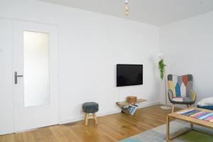 sala de estar con TV en la pared en EXIGEHOME-Grande maison aux portes de Paris, en Antony