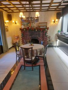 a dining room with a table and a fireplace at Hedonist Zlatibor Mountain Wellness & SPA in Zlatibor