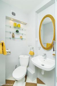 biała łazienka z toaletą i umywalką w obiekcie Apartament na Traugutta w Elblągu