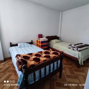two twin beds in a room with at Departamento-Parque y Flores M1 in Chiclayo
