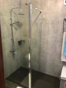 um chuveiro com uma porta de vidro na casa de banho em Casa do Largo - Açores em Ponta Delgada