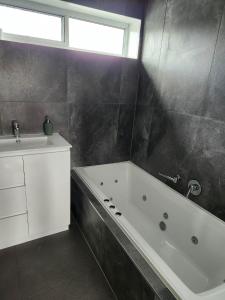 ein Badezimmer mit einer Badewanne und einem Waschbecken in der Unterkunft Budget on the Lake in Hamilton