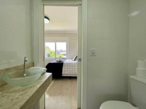 baño con lavabo y cama en Casa TRIPLEX 3 dorm a 6QD RUA COBERTA CANELA, en Canela