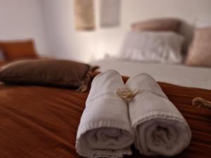 a pair of towels sitting on top of a bed at La Maison de Lyna in Aigues-Mortes